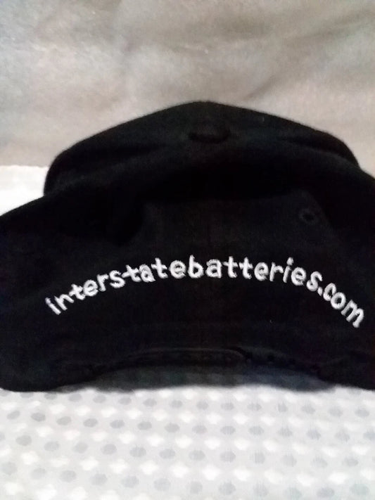 Black cap with 'interstatebatteries.com' text on a textured surface