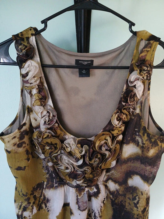 Floral-patterned tank top on a hanger against a light blue background