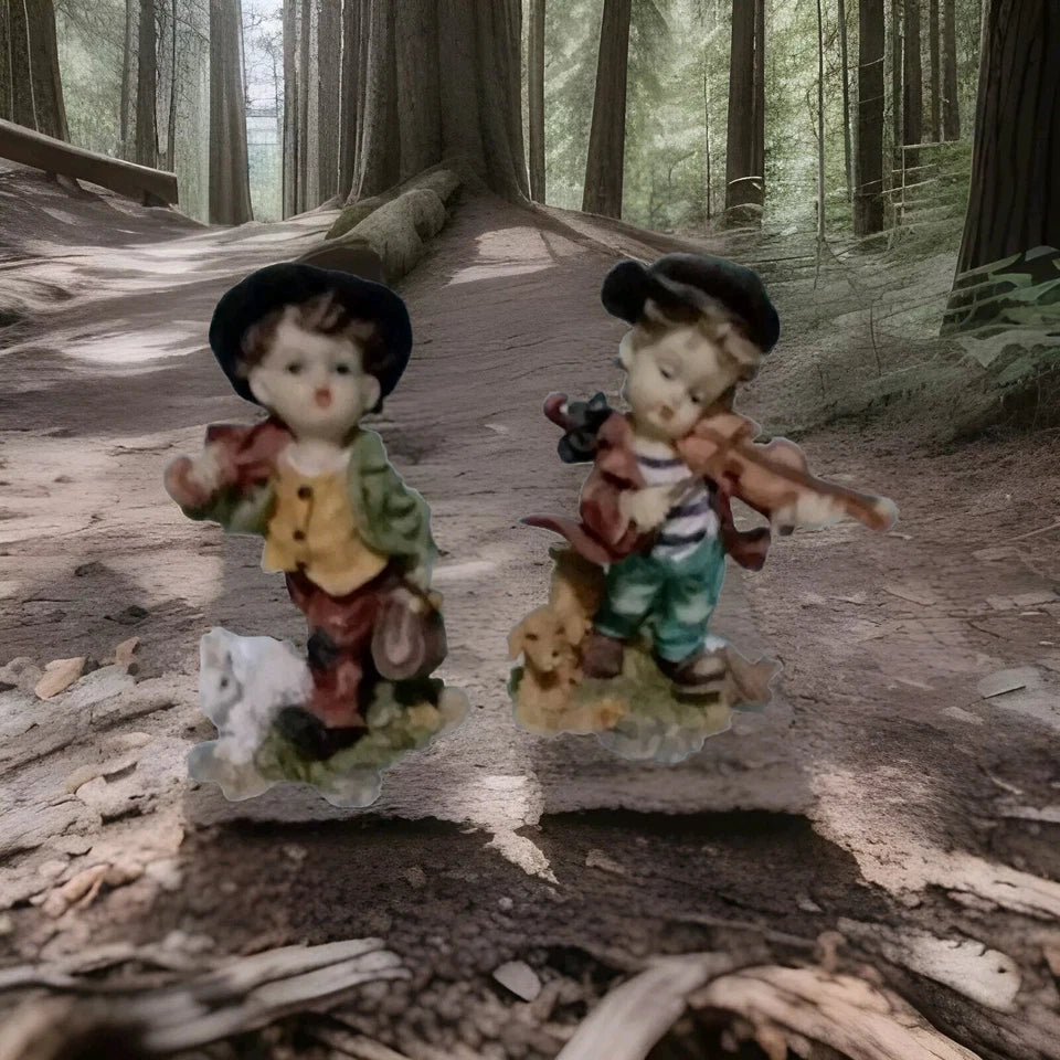 Two figurines of a boy and a bear with a dog on a forest floor.