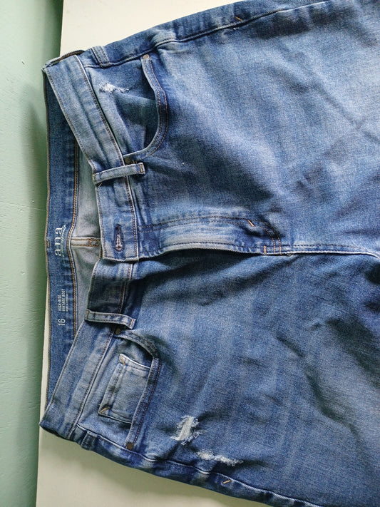 Blue denim pants with visible branding on a light background