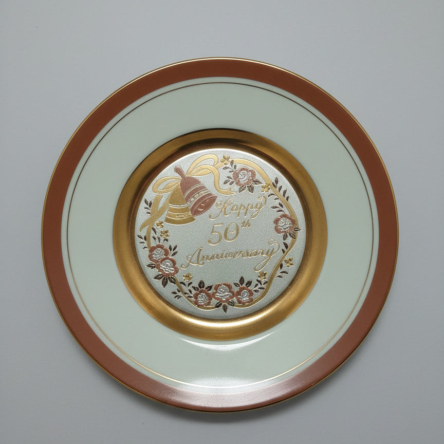 Decorative plate with gold rim and intricate design on a textured white background